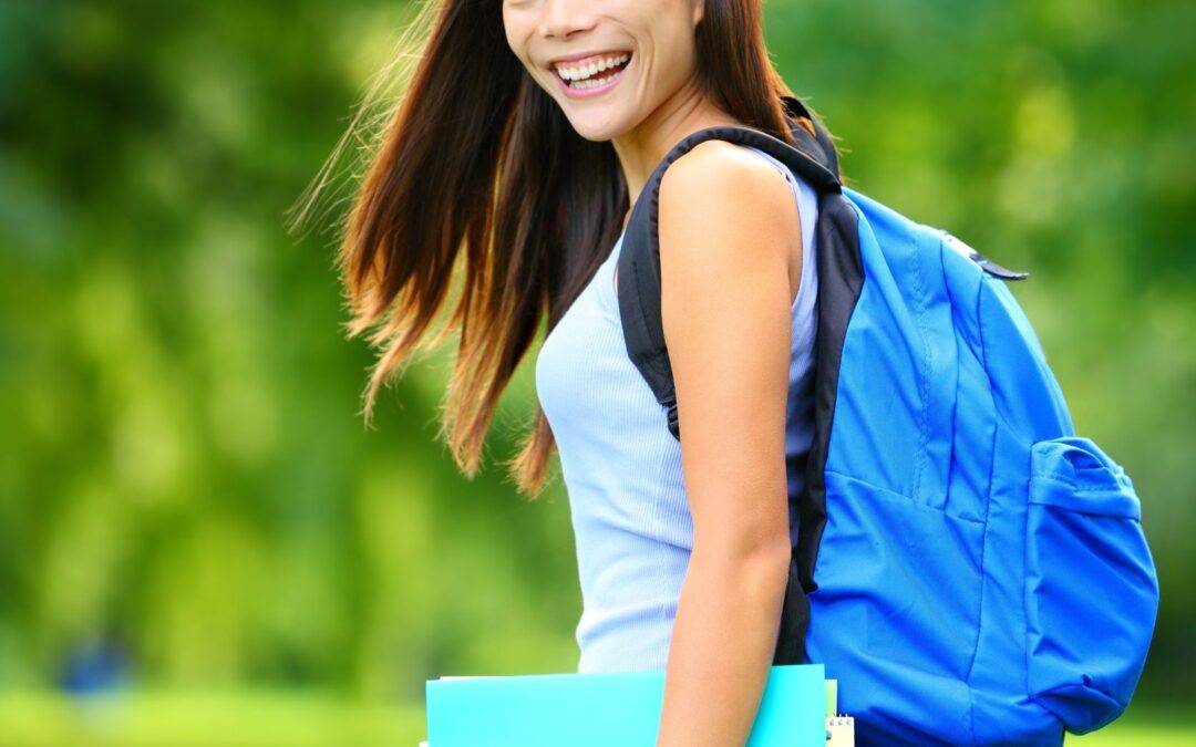 university college student girl standing happy smiling with book or notebook in campus park beautiful young mixed race asian caucasian young woman brunette