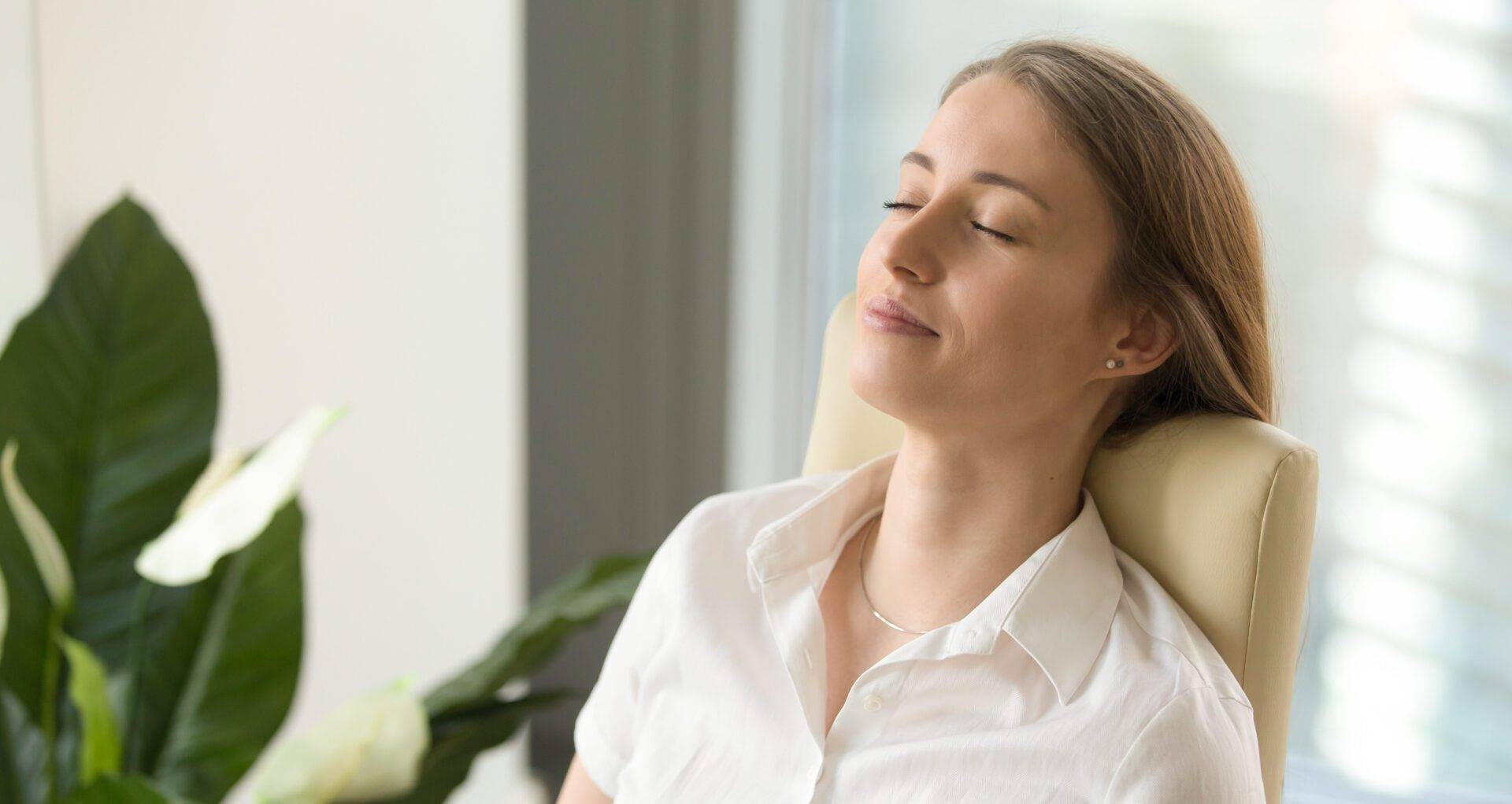 Calm attractive woman feeling relaxed leaning back on office